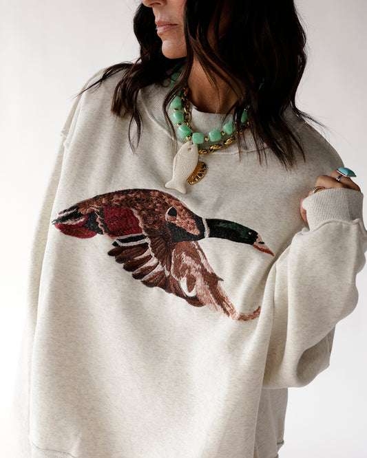 Light gray mallard duck mockneck featuring a flying mallard duck graphic. A cozy, casual layer perfect for outdoor lovers and everyday wear.