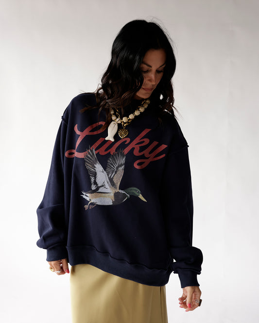 Reversible navy blue mallard duck mockneck featuring a flying duck and “LUCKY” on one side and a flying mallard duck on the other.