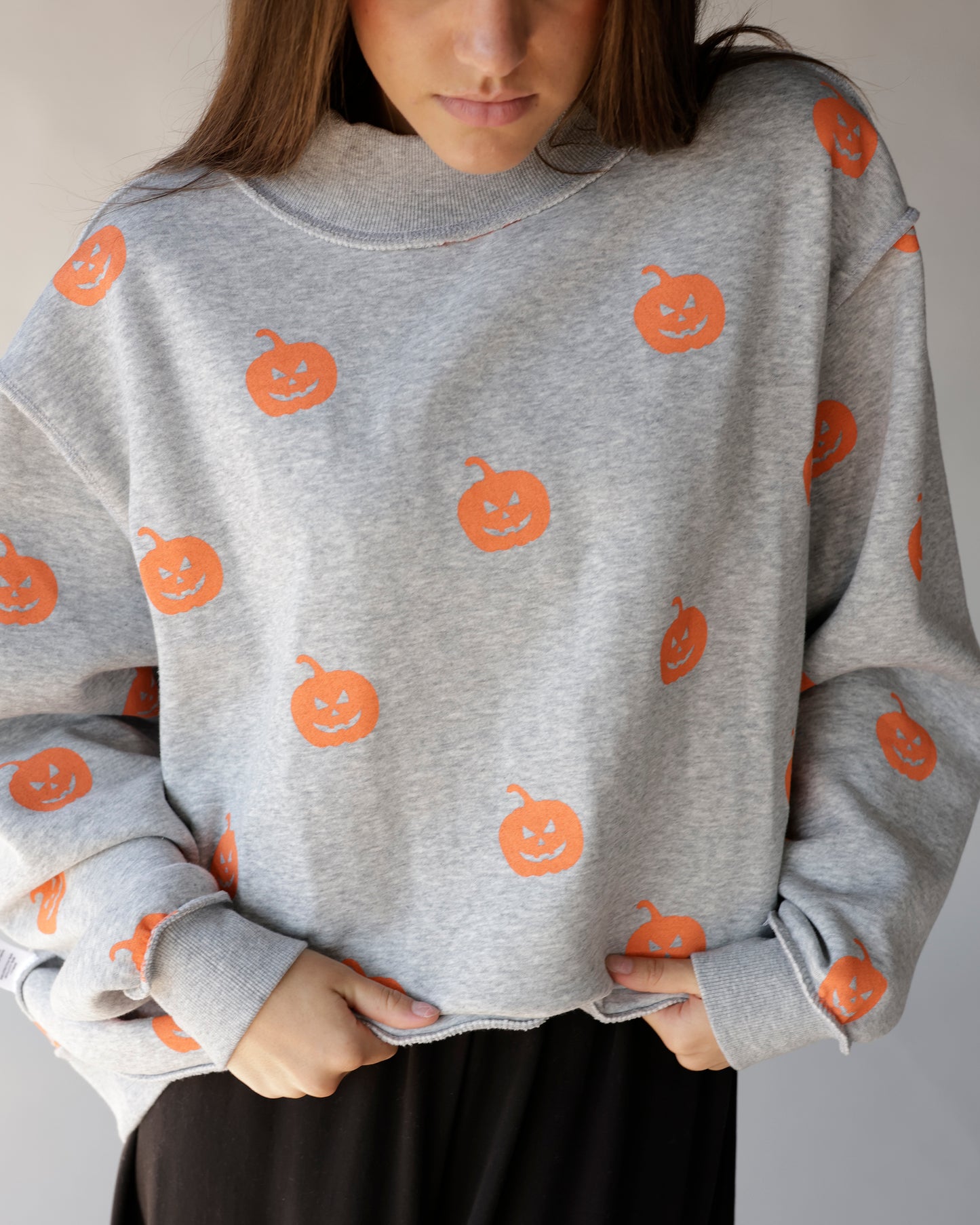 Gray mock neck sweatshirt with allover orange jack-o-lantern Halloween pumpkin print
