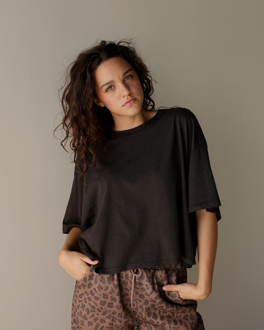 daydreamer vintage black cropped t-shirt with a relaxed boxy fit, ribbed crew neckline, dropped shoulders and roomy short sleeves, styled with leopard pants.