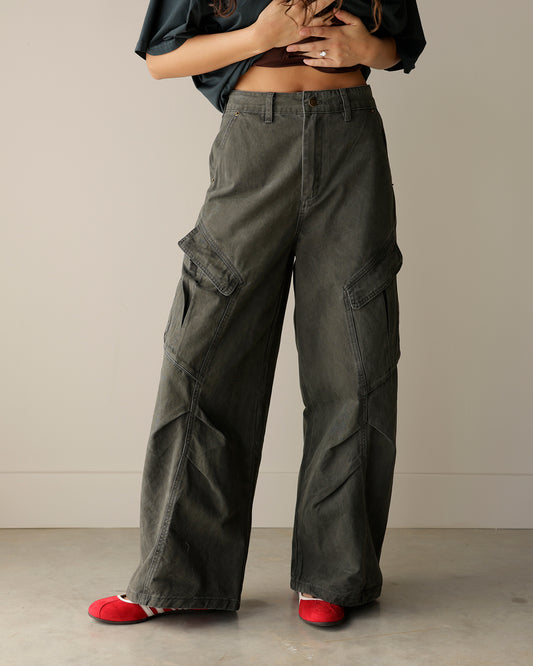 woman wearing mimosa washed charcoal-olive wide-leg cargo pants with oversized flap pockets, belt loops and a relaxed utility-inspired fit.