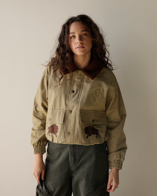 girl wearing utility jacket with buffalo and horses wearing cargo pants lucky horseshoe on back