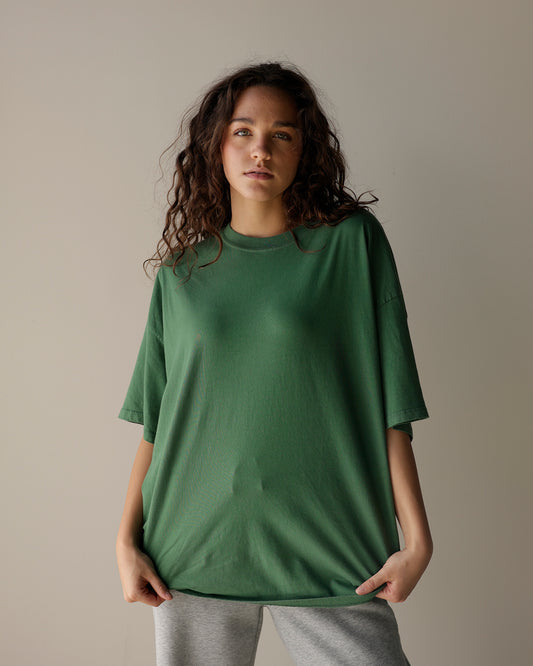 daydreamer oversized green crewneck t-shirt with dropped shoulders, relaxed short sleeves and a loose fit, styled with gray sweatpants.