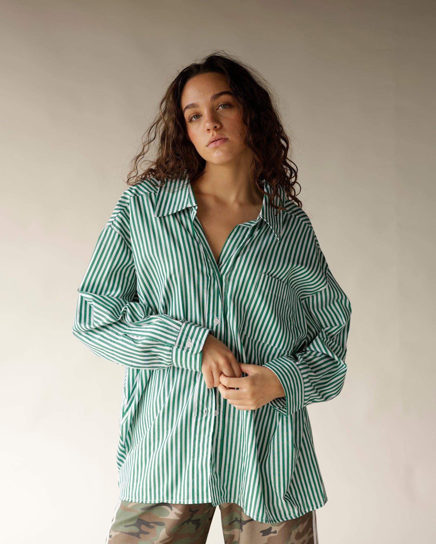 Oversized green and white striped button-up shirt with long sleeves and chest pocket