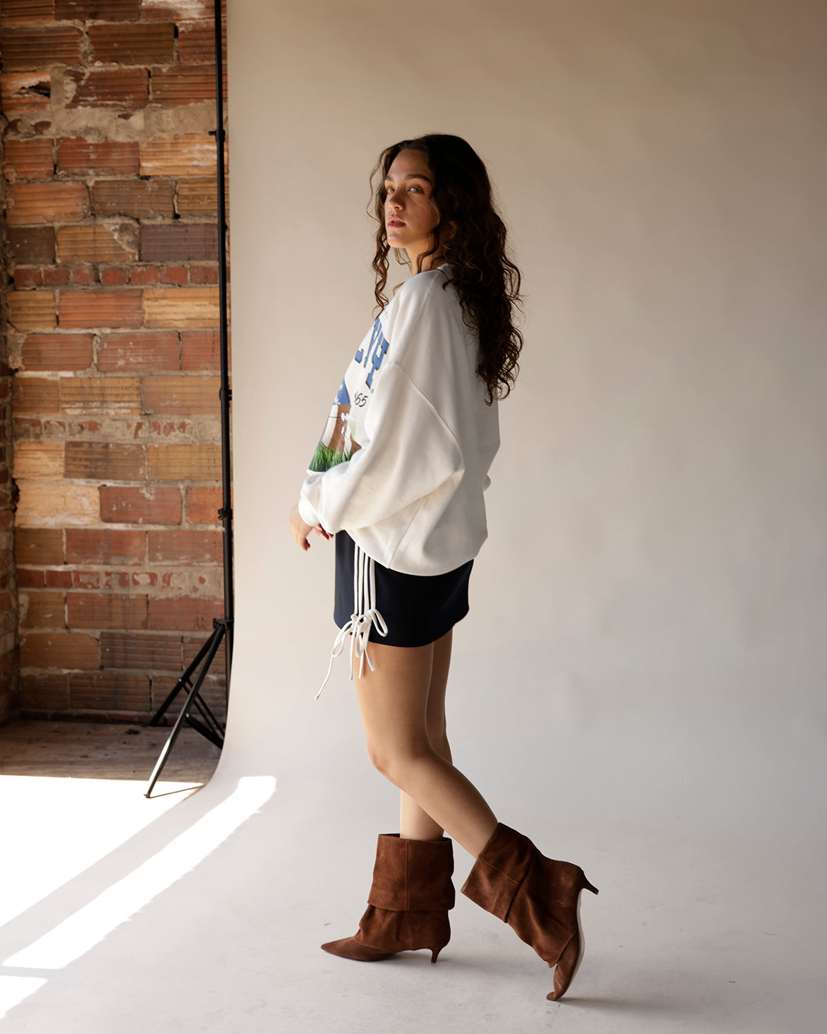 Taupe suede ankle booties with kitten heel and slouchy shaft on model