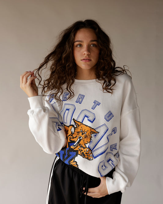 White oversized Wildcats crewneck sweatshirt with blue varsity letters and wildcat mascot graphic