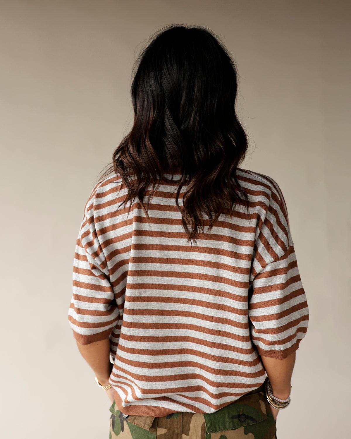 Women's brown and white striped knit sweater with elbow-length sleeves, back view
