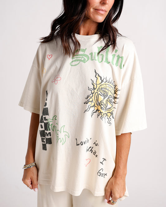 Oversized cream graphic tee with sun, palm trees, hearts, and Sublime-inspired text