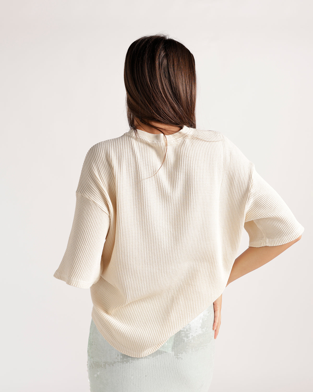 Cream ribbed short-sleeve oversized tee shown from the back on a model.