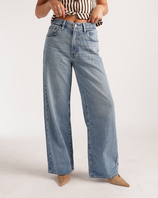 Wide leg light wash blue denim jeans with relaxed fit and vintage fading