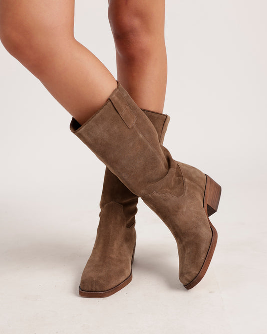 Knee-high taupe suede boots with block heel and pointed toe on model