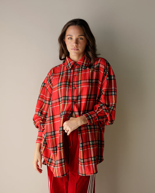 model wearing oversized red plaid button up with red track pants
