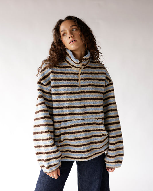 Striped sherpa quarter-zip pullover in blue, beige, and brown on a model