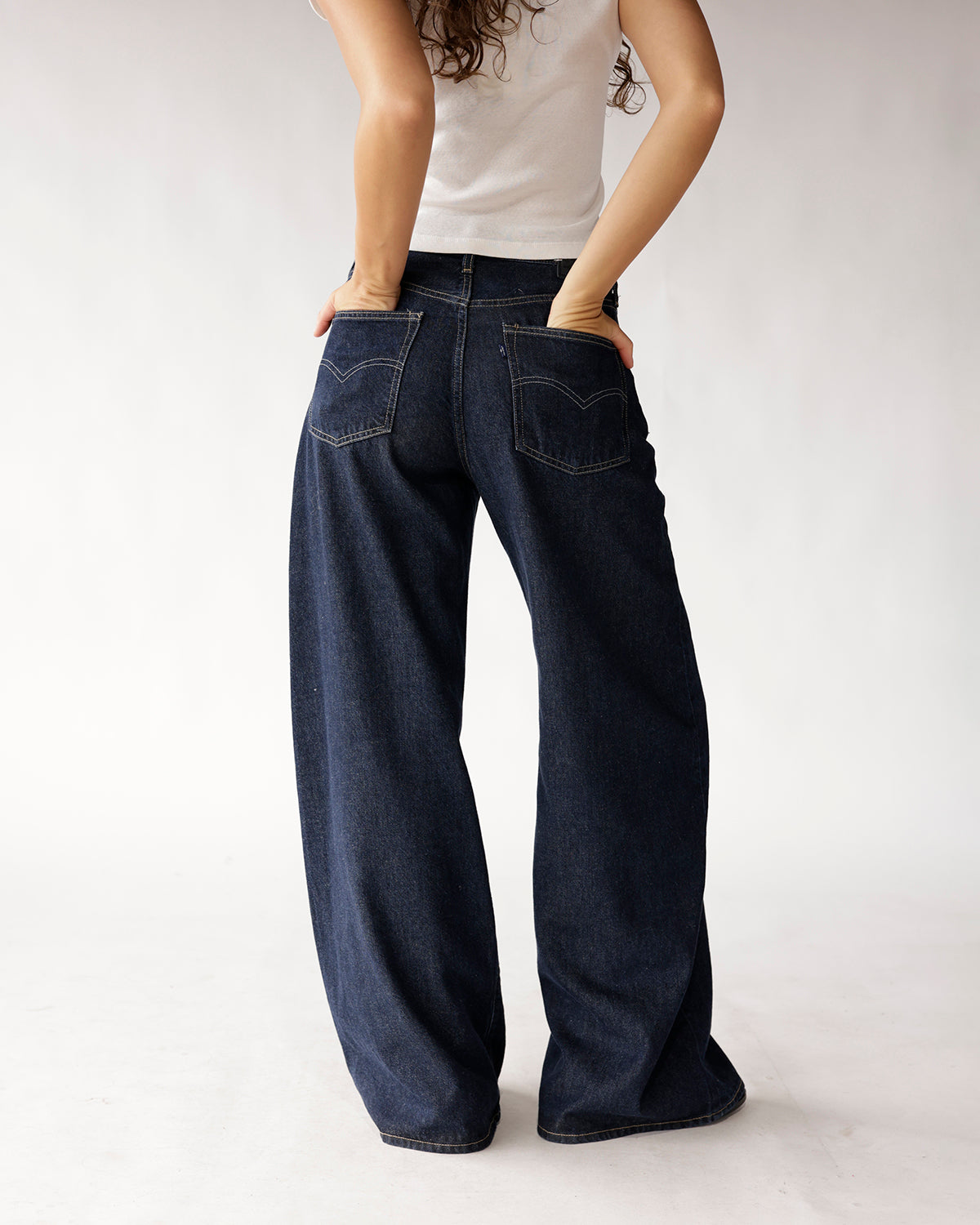 Dark wash wide-leg jeans with arc pocket stitching, back view