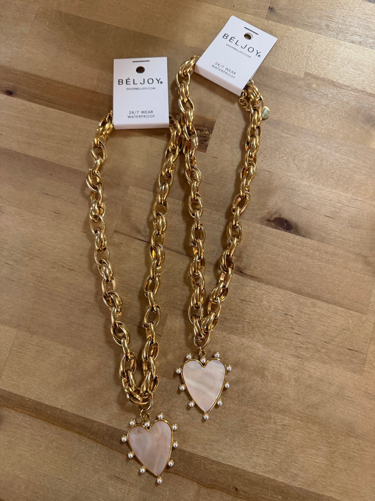 Two gold chunky chain necklaces with pearl-trimmed mother-of-pearl heart pendants