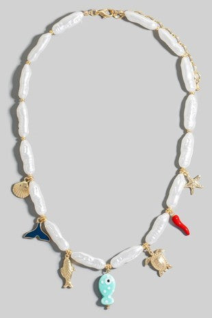 Necklace with shell beads and colorful charm pendants on a gray background