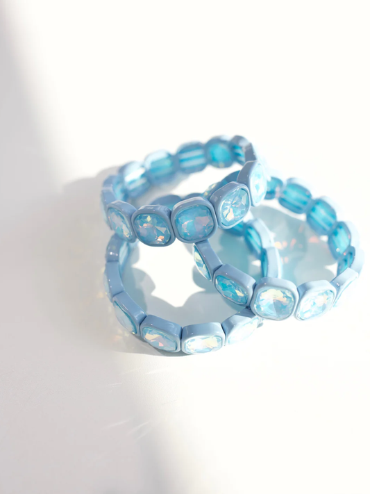 Stacked light blue stretch bracelets with cushion-cut iridescent crystal stones