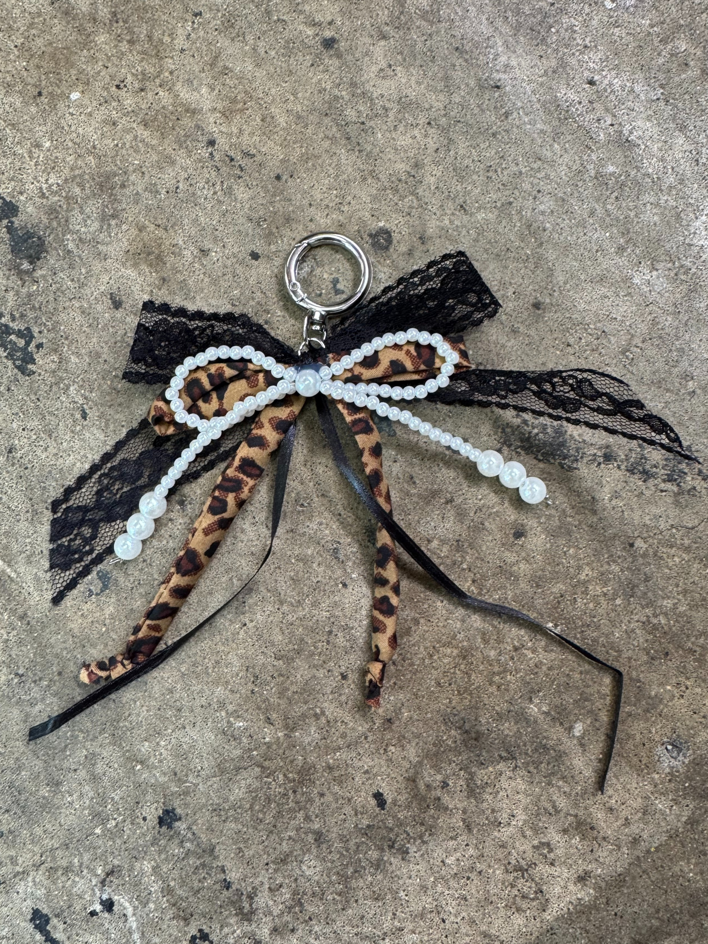 bow keychain with pearl bow, black ribbon bow, tulle ribbon bow, and a brown fabric leopard bow