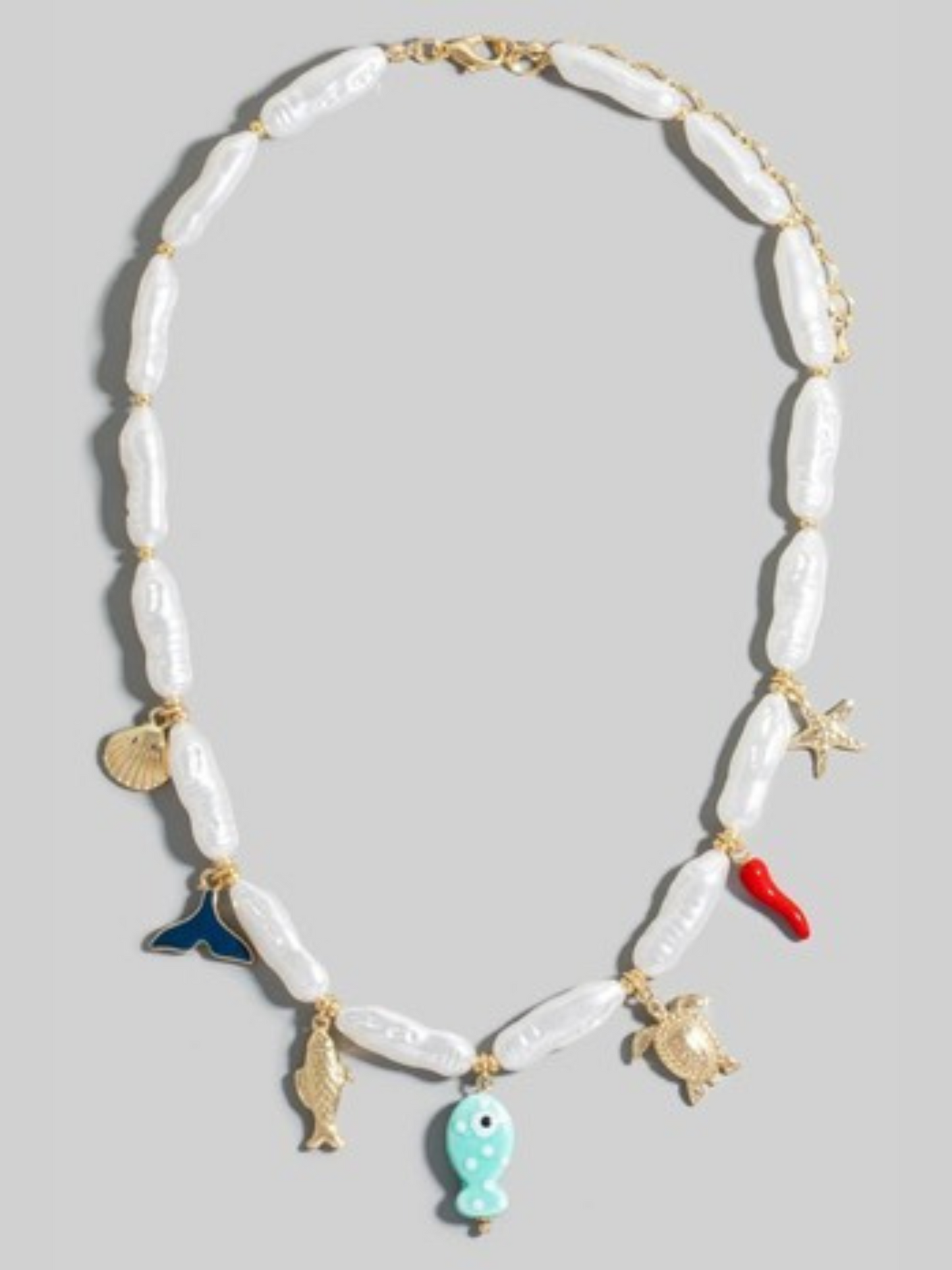 Necklace with shell beads and various charms on a light gray background