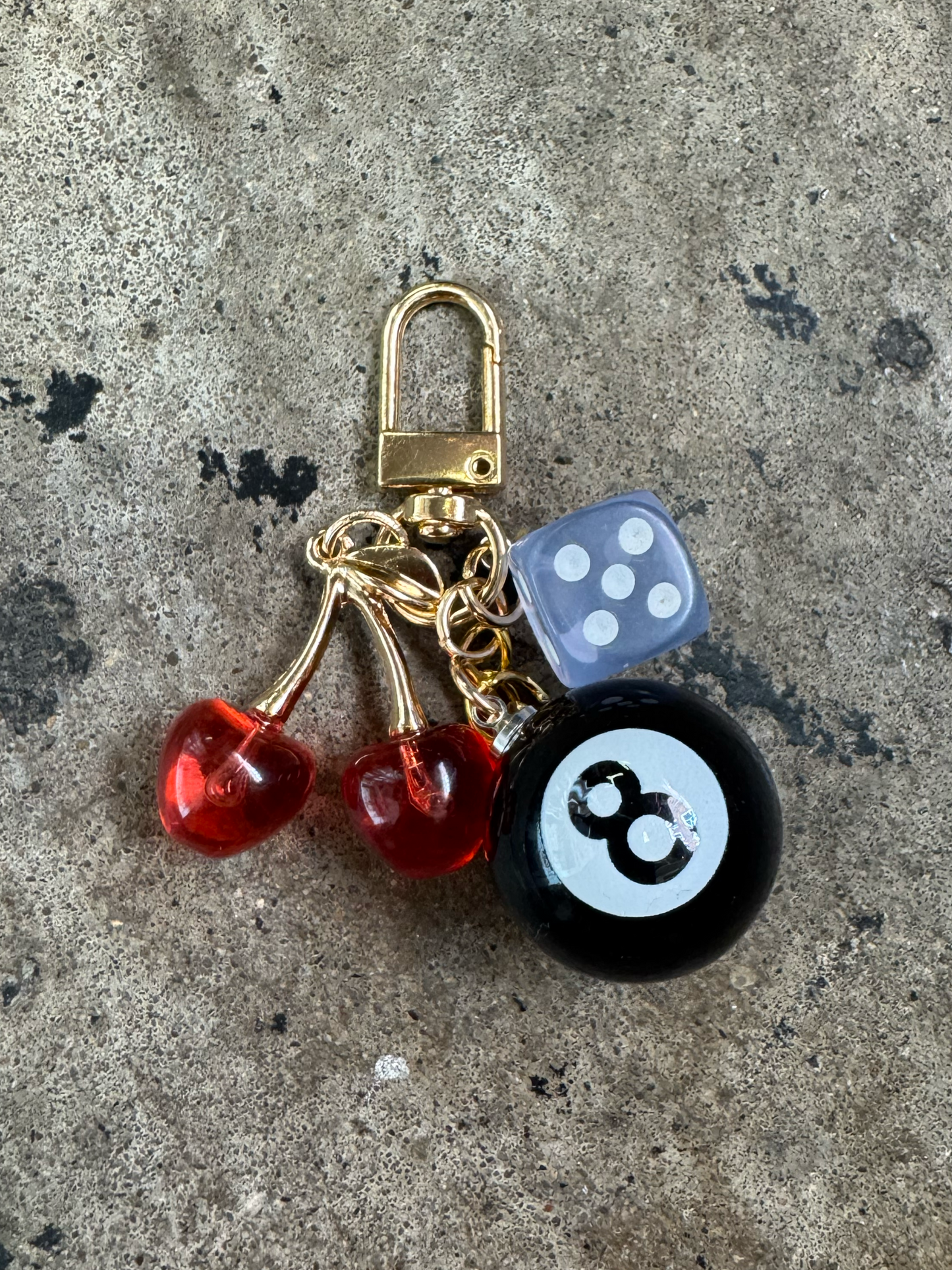 key chain with a pool 8 ball, cherries, and a light blue dice