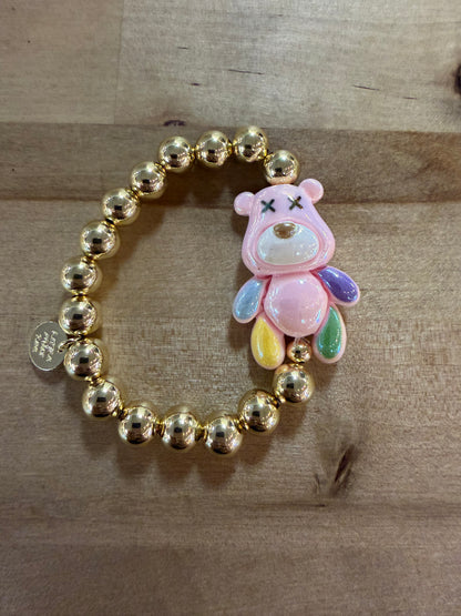 Gold beaded stretch bracelet with pink bear charm and colorful teardrop accents