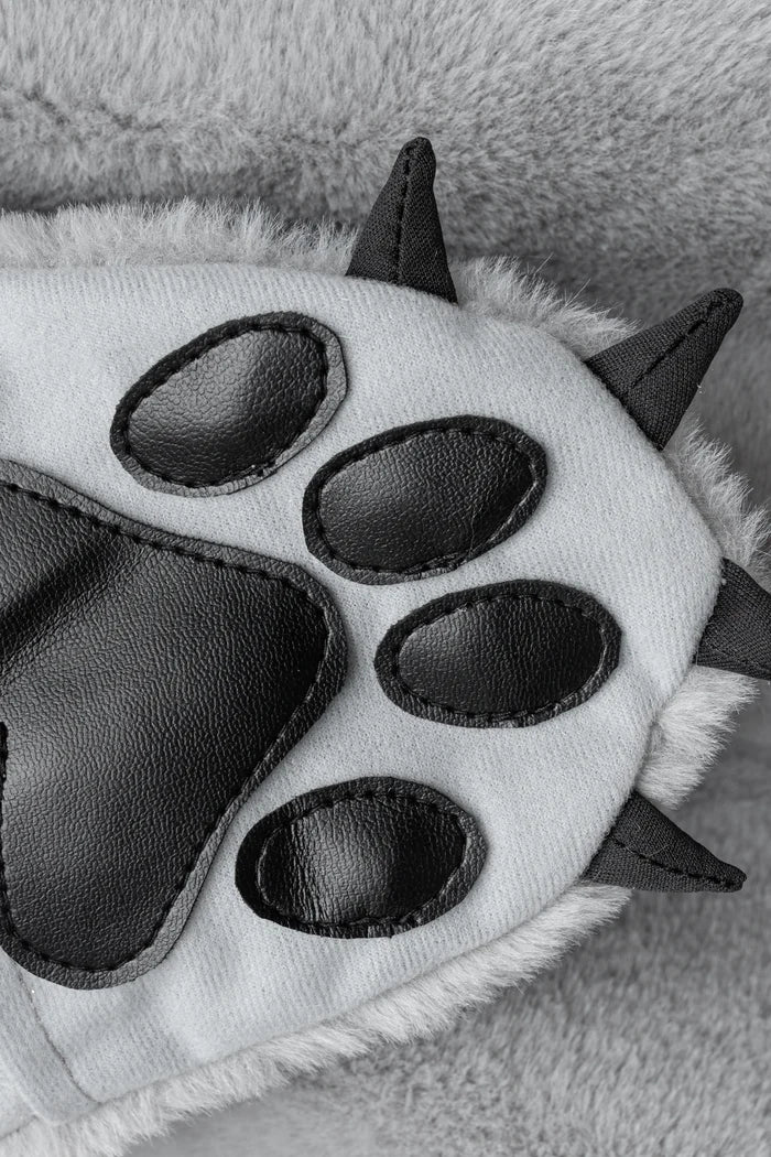 Close-up of gray furry wolf paw glove with black faux leather pads and spikes