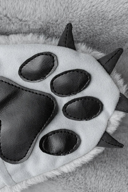 Close-up of gray furry wolf paw glove with black faux leather pads and spikes