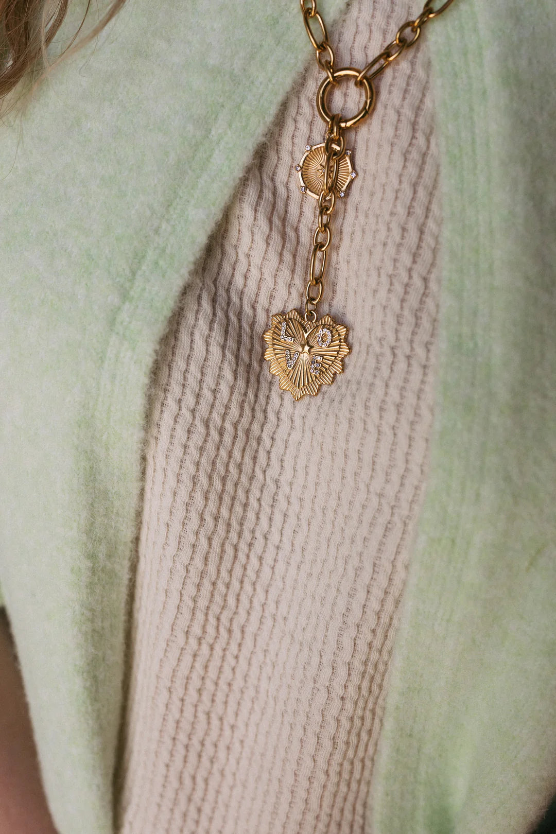 Gold chain necklace with heart-shaped charm featuring crystal letter details