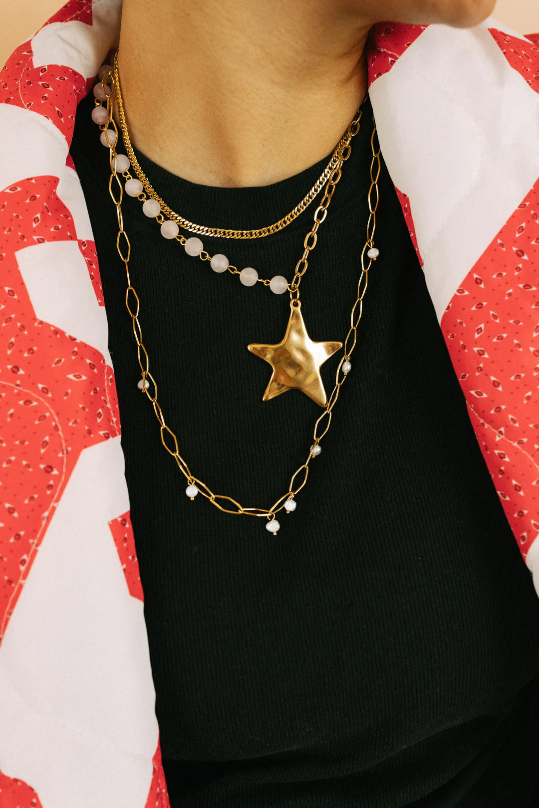 Layered gold star pendant necklace with pearl chain and beaded strands