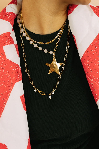 Layered gold star pendant necklace with pearl chain and beaded strands