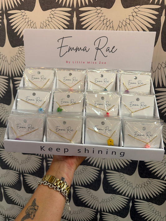 Gold chain necklaces with colorful bubble initials displayed in retail box tray