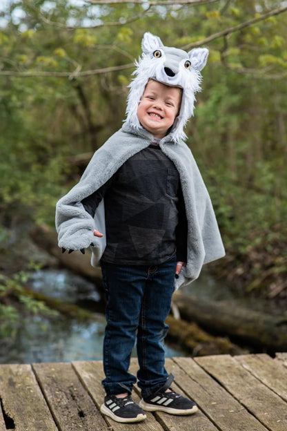 Child wearing gray wolf cape costume with hood, claws, and white fur trim