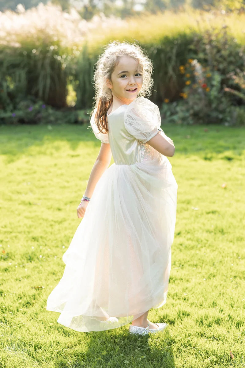 Girl wearing a long white sparkle tulle dress with puff sleeves outdoors