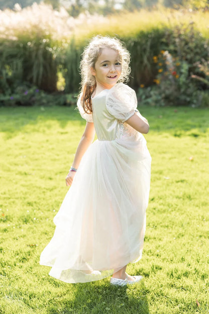 Girl wearing a long white sparkle tulle dress with puff sleeves outdoors