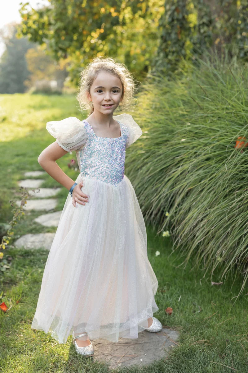 Girl wearing white tulle gown with iridescent sequin bodice and puff sleeves