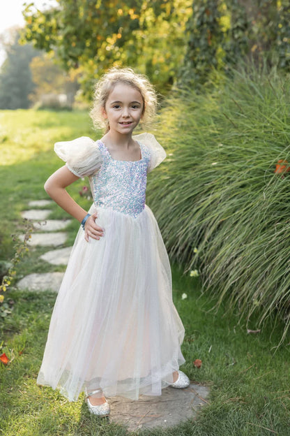 Girl wearing white tulle gown with iridescent sequin bodice and puff sleeves