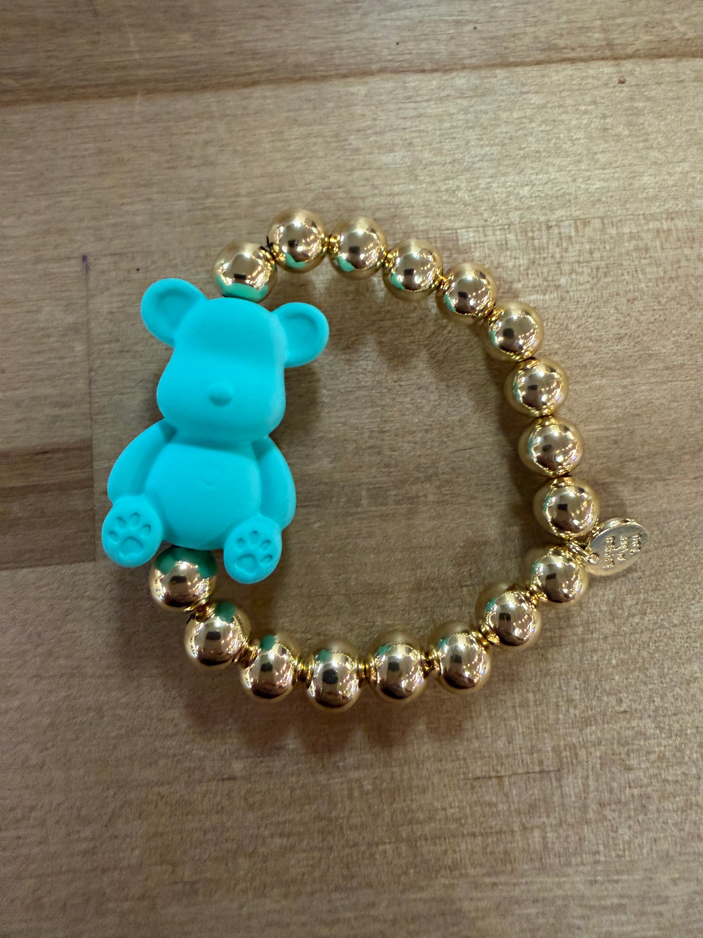 Gold beaded stretch bracelet with turquoise blue teddy bear charm centerpiece