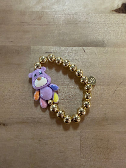Gold beaded stretch bracelet with purple bear charm and colorful accents