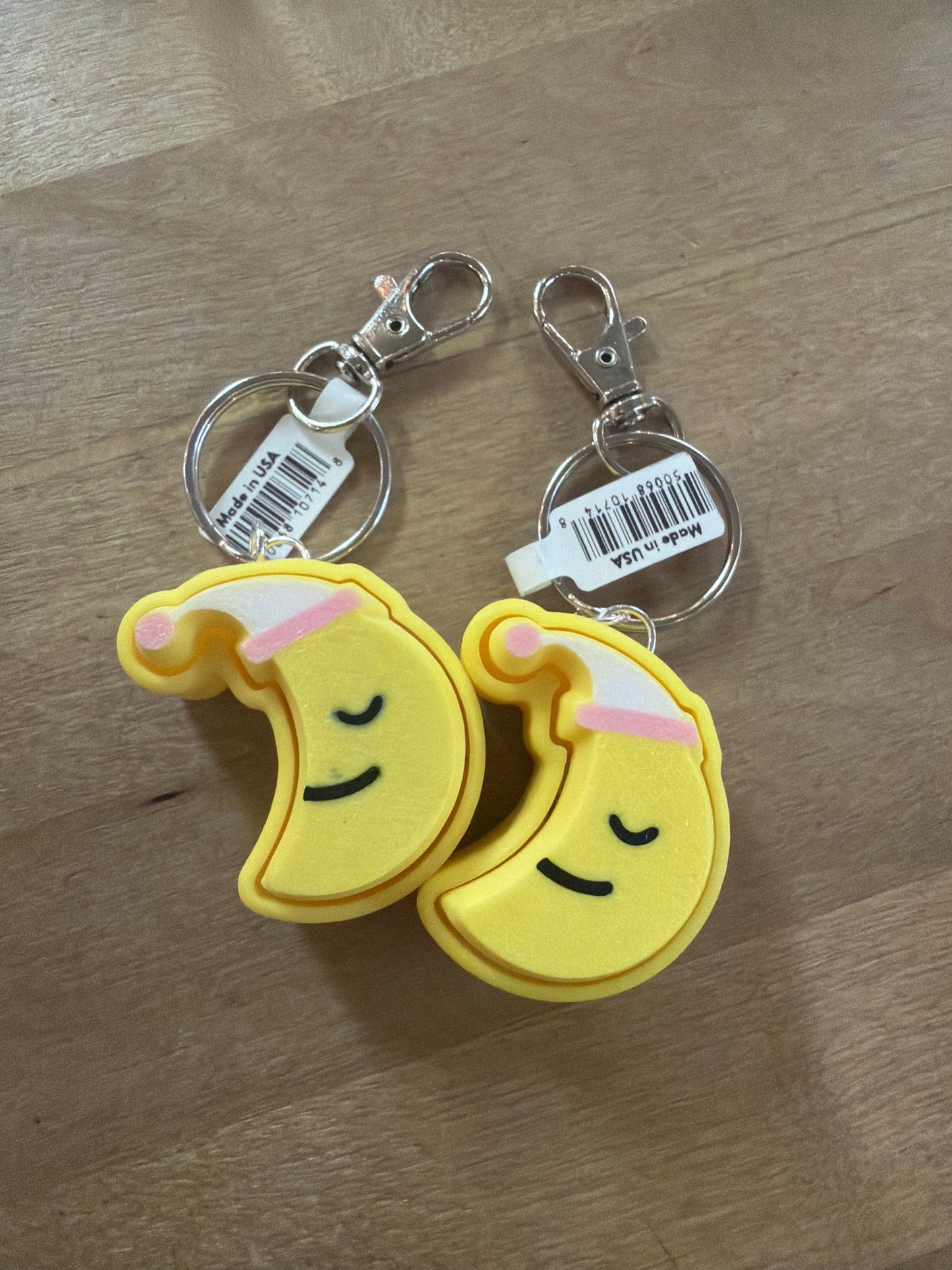 Two yellow crescent moon rubber keychains with sleepy faces, silver lobster clasp