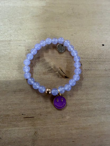 Lavender beaded stretch bracelet with purple enamel smiley face gold-rimmed charm