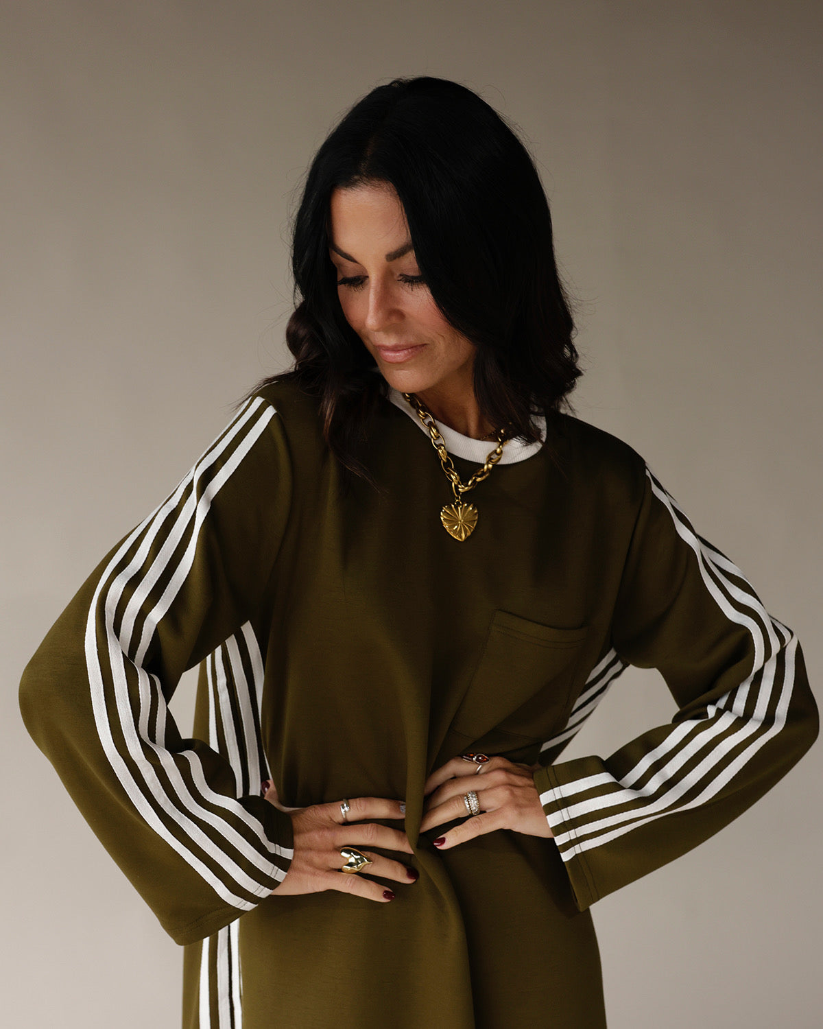 Olive green varsity track dress with white side stripes and long sleeves