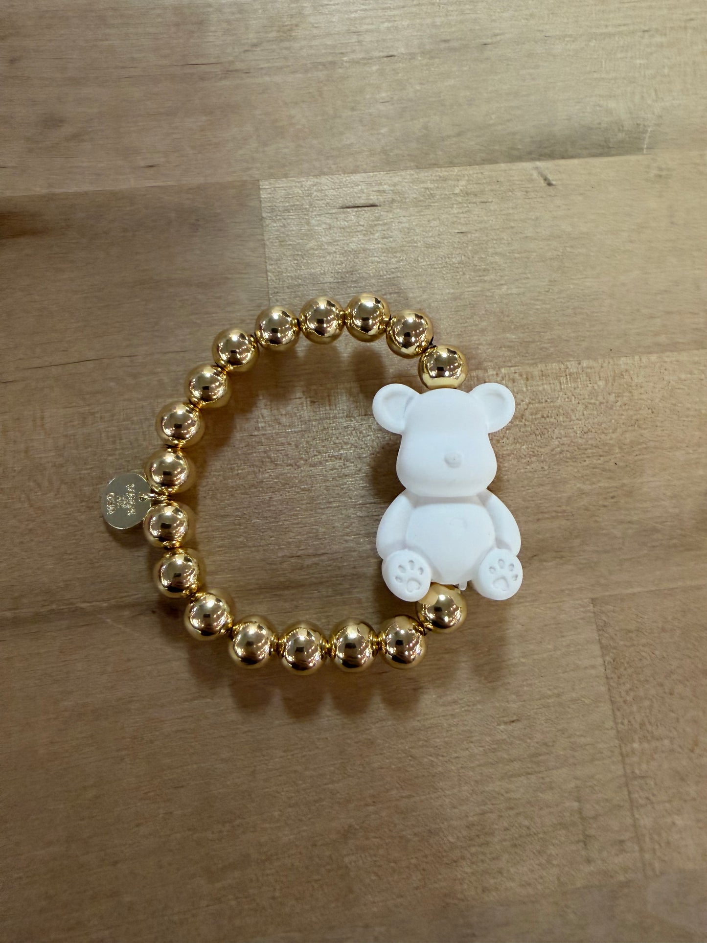 Gold beaded stretch bracelet with white teddy bear charm pendant