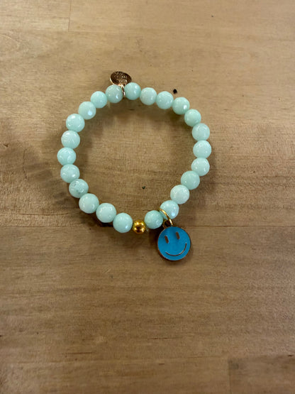 Light blue beaded stretch bracelet with a turquoise enamel smiley face charm