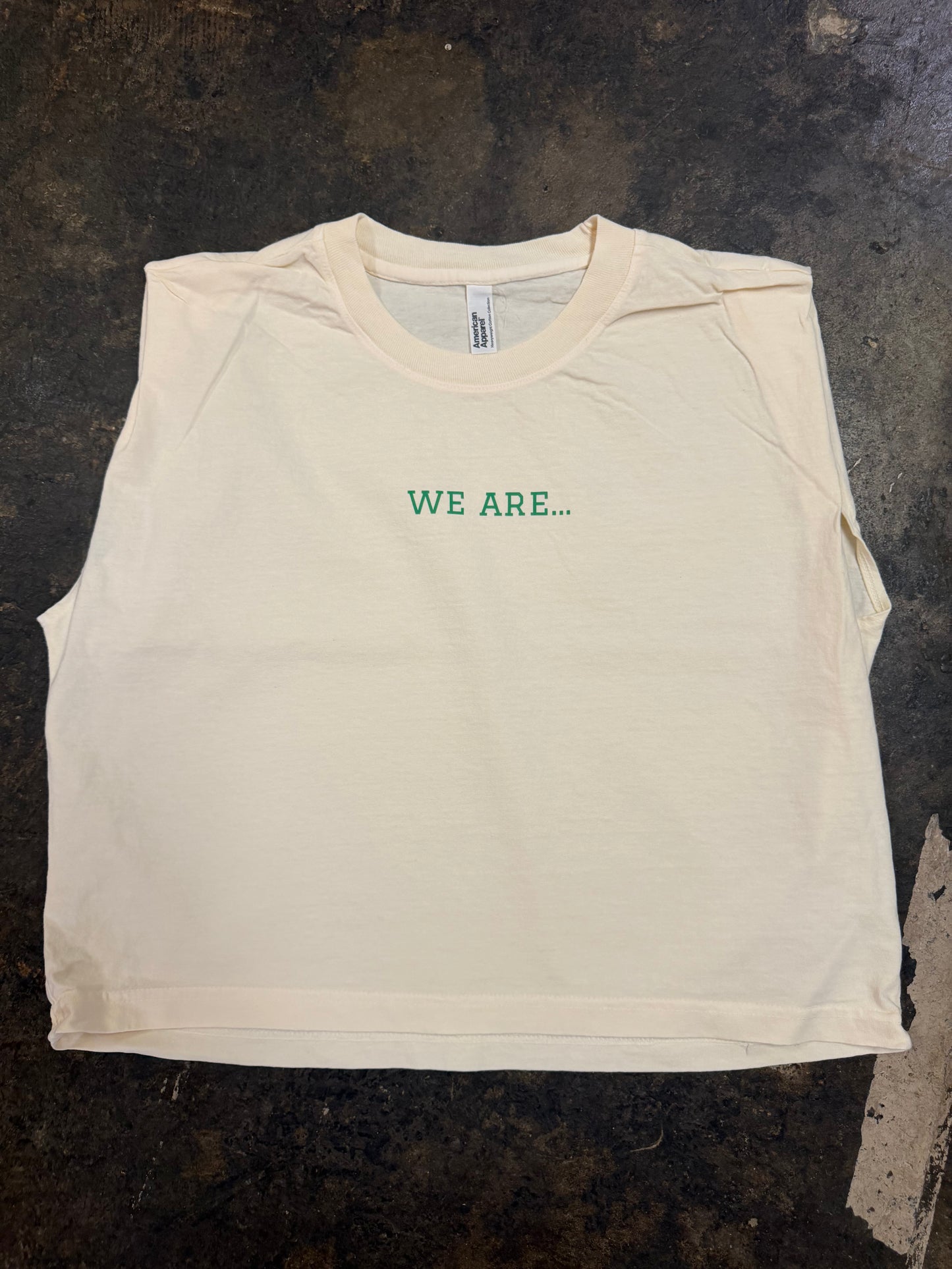 Off-white sleeveless muscle tee with green WE ARE… text on chest