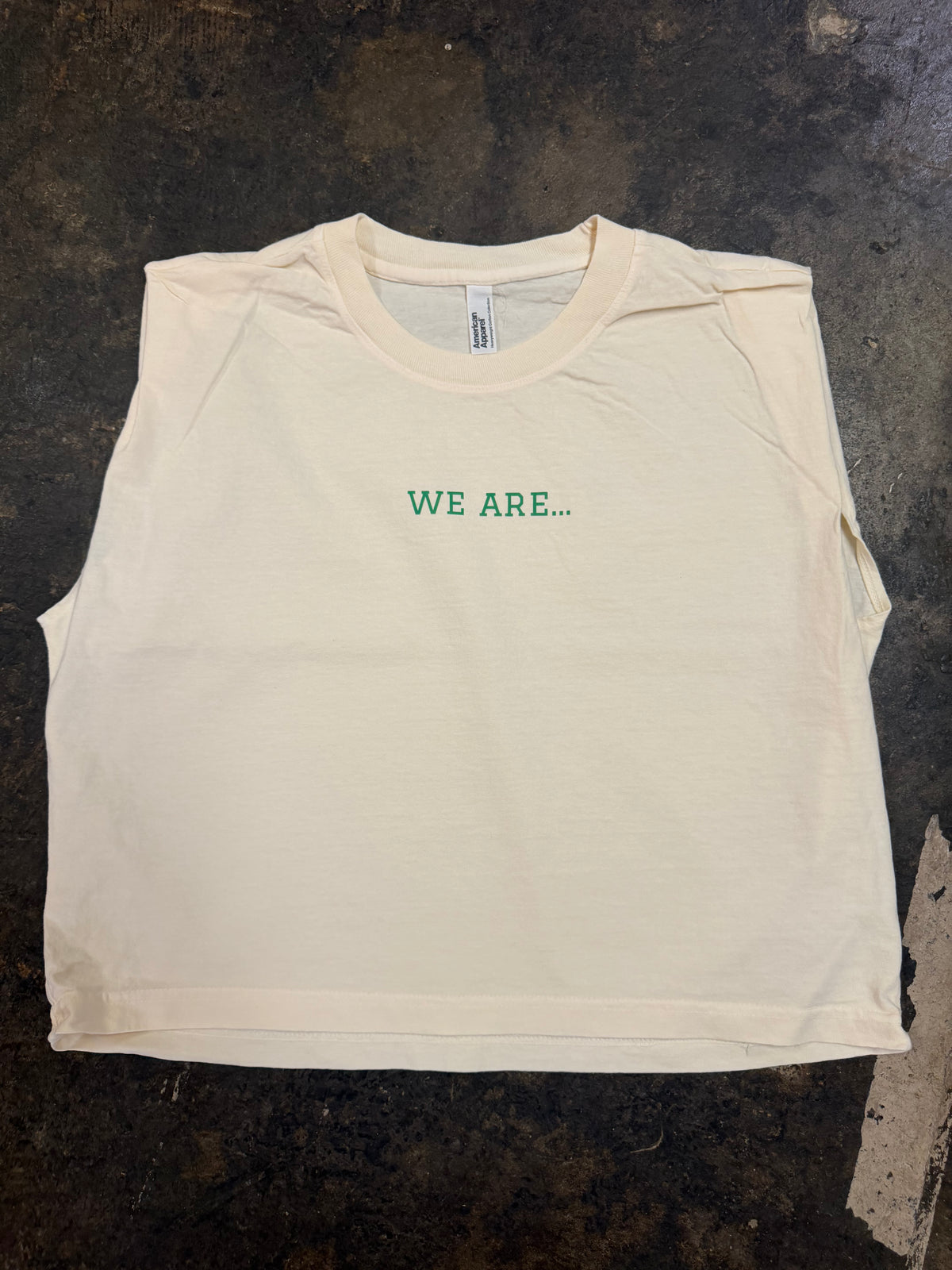 Off-white sleeveless muscle tee with green WE ARE… text on chest