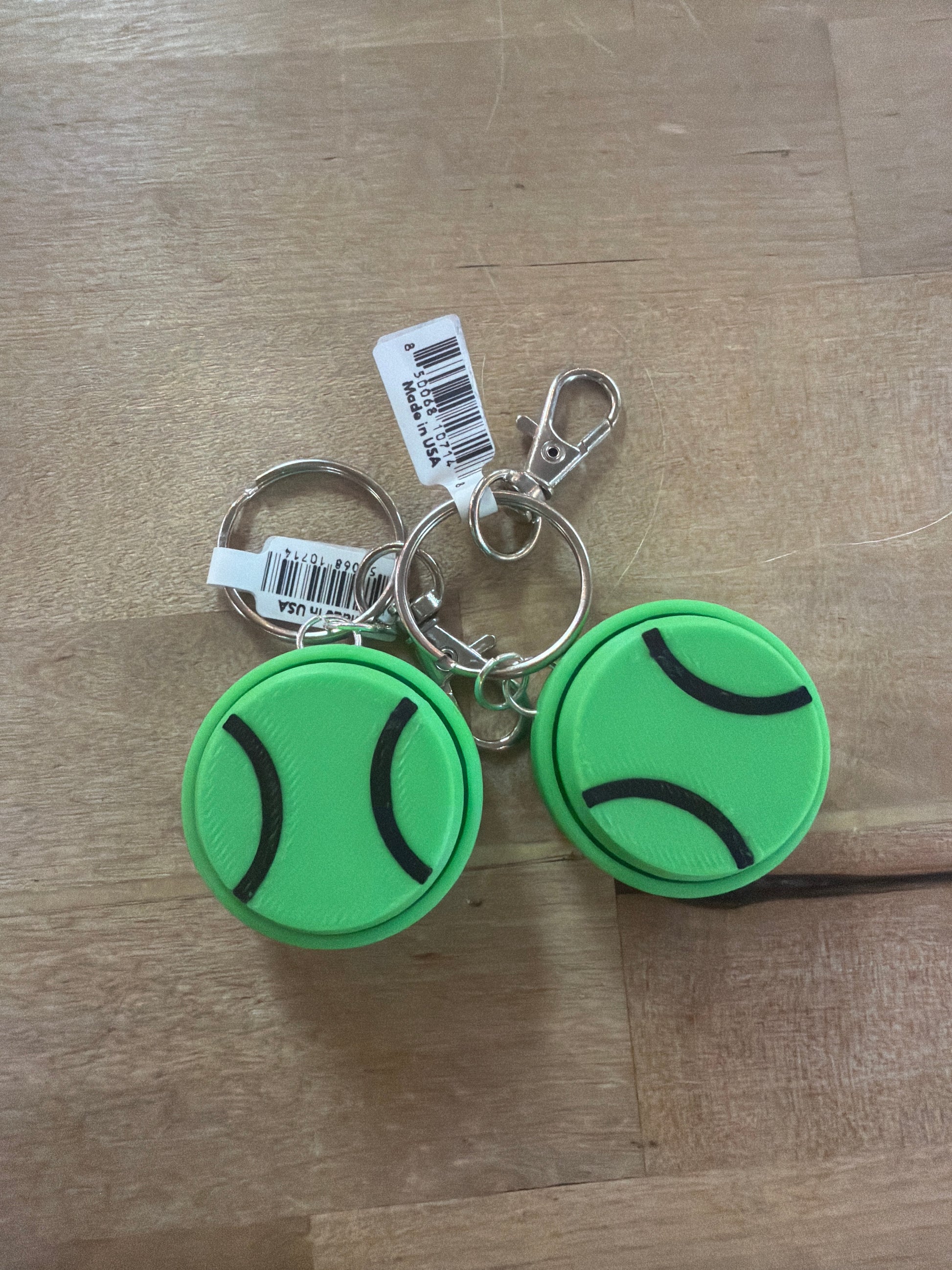 Two green tennis ball rubber keychains with silver lobster clasp and split ring