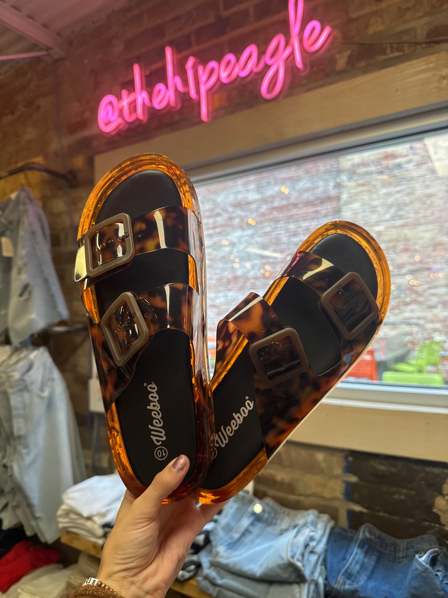 Tortoiseshell double strap jelly slide sandals with square buckles and amber translucent sole