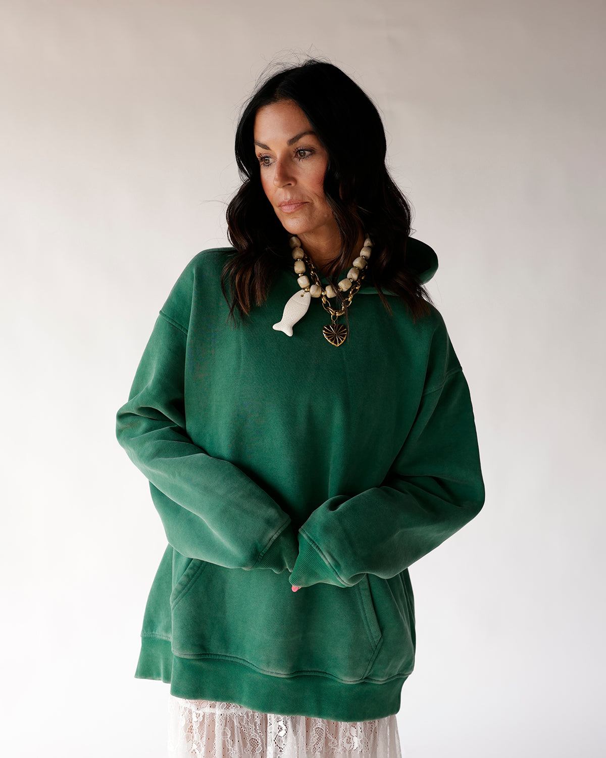 Oversized green hoodie sweatshirt with kangaroo pocket, worn with lace skirt