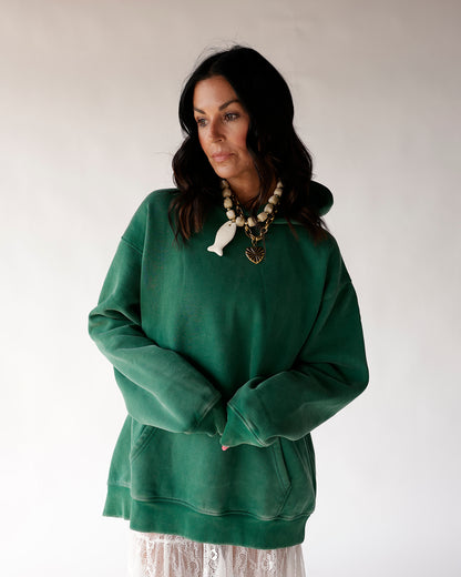 Oversized green hoodie sweatshirt with kangaroo pocket, worn with lace skirt
