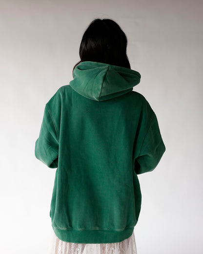 Back view of oversized green hoodie with hood up, paired with white lace skirt